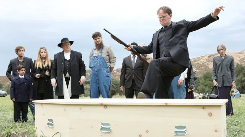 Dwight Schrute (Rainn Wilson) kicks open a coffin as his family watches in The Office (2005)