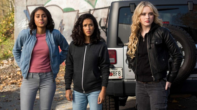 Patience Turner (Clark Backo), Kaia Nieves (Yadira Guevara-Prip), and Claire Novak (Kathryn Newton) stand by a Jeep in Supernatural
