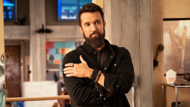 Ian Grimm grinning contentedly with arms crossed across chest
