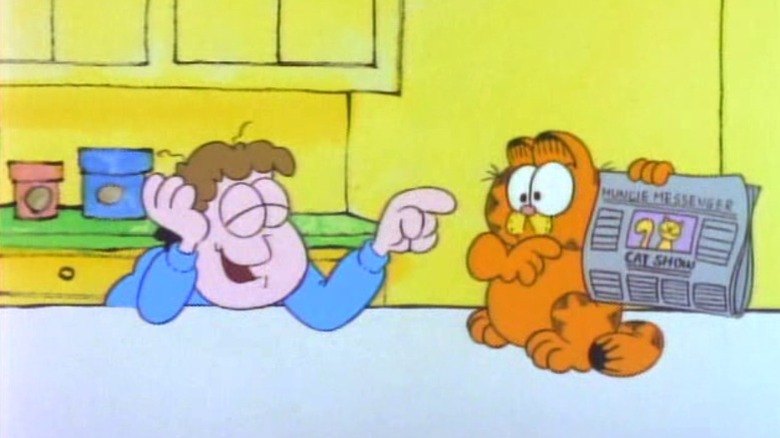 Jon pointing and laughing at Garfield holding a newspaper on Garfield and Friends S1E11