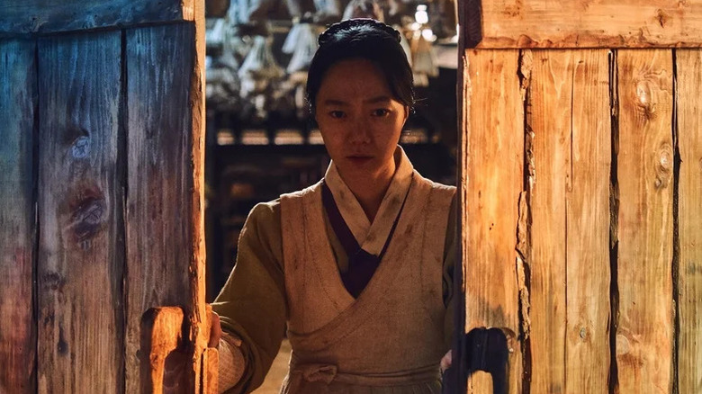 Doona Bae as Seo-bi opening a wooden gate in "Kingdom."