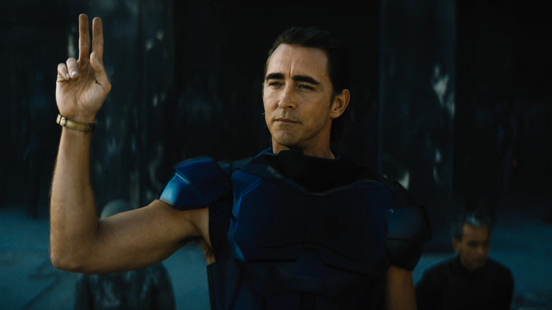 Lee Pace as Brother Day in blue armor holding up two fingers in Foundation