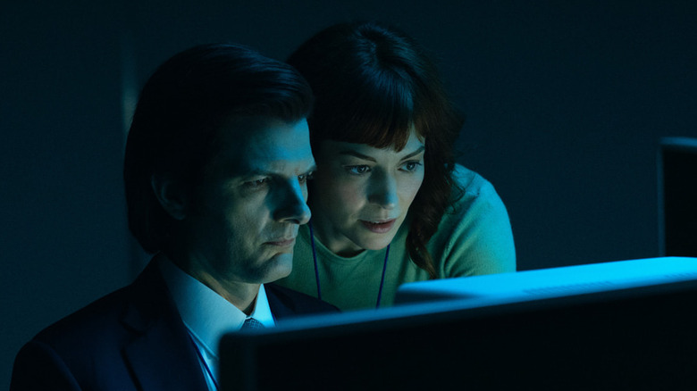 Adam Scott and Britt Lower as Mark S. and Helly R. looking at a computer in the dark in Severance
