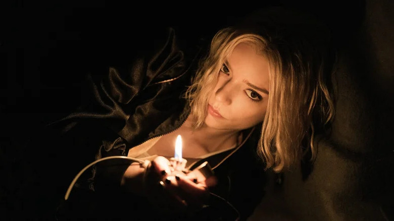 Anya Taylor-Joy as Lucky with face lit up by lighter in Lucky