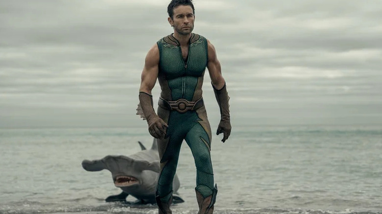 The Deep (Chace Crawford) walks away from a hammerhead shark (Samuel L. Jackson) yelling at him from the ocean in The Boys