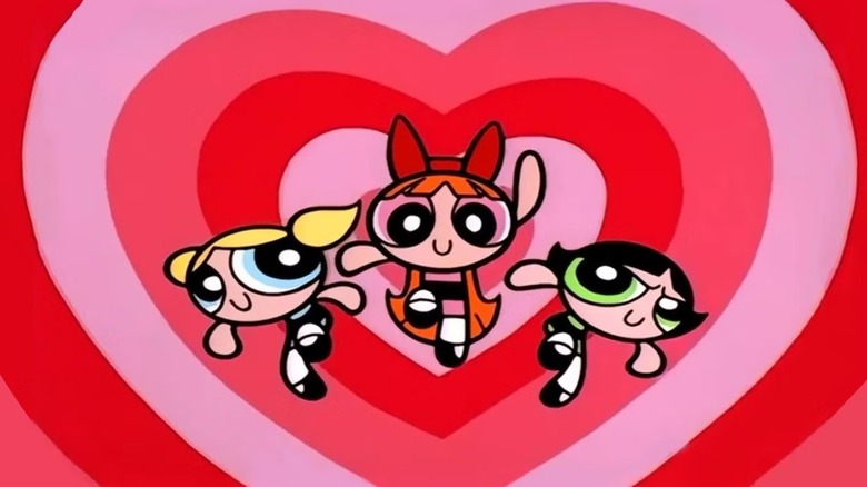 Bubbles (Tara Strong), Blossom (Cathy Cavadini), and Buttercup (E.G. Daily) fly up with a heart background in The Powerpuff Girls