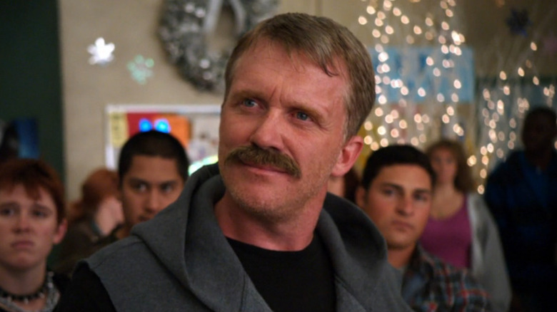 Anthony Michael Hall as Mike Chilada, standing in the cafeteria in Community.
