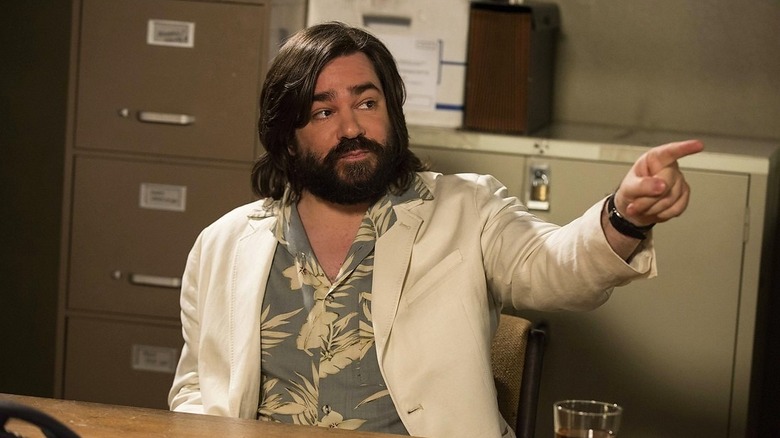 Matt Berry as Roger DeSalvo, pointing a desk in Community.