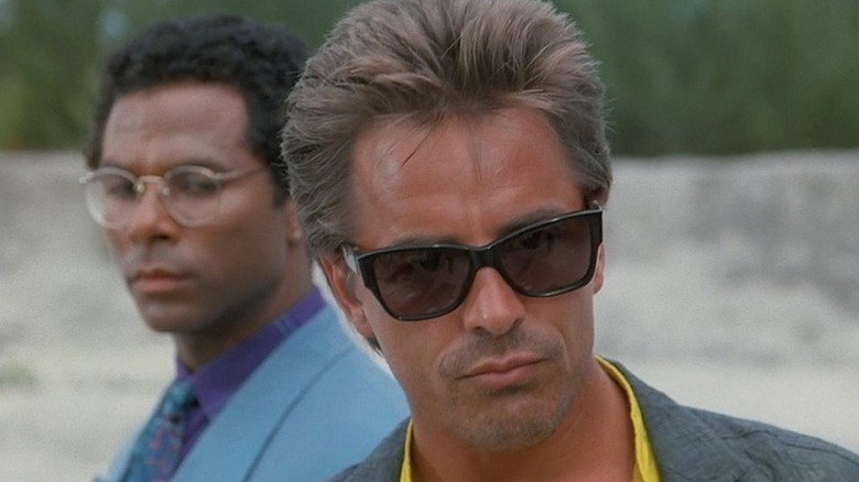 Rico Tubbs (Philip Michael Thomas) and Sonny Crockett (Don Johnson) stand on a beach in Miami Vice