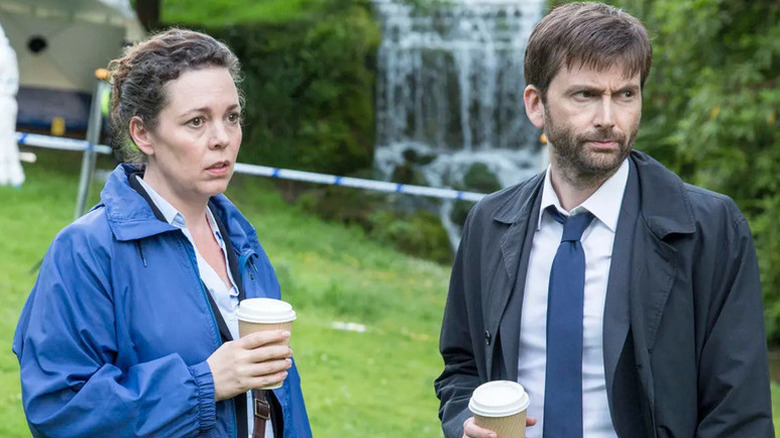Ellie Miller (Olivia Colman) and Alec Hardy (David Tennant) stand outside holding coffee cups in Broadchurch