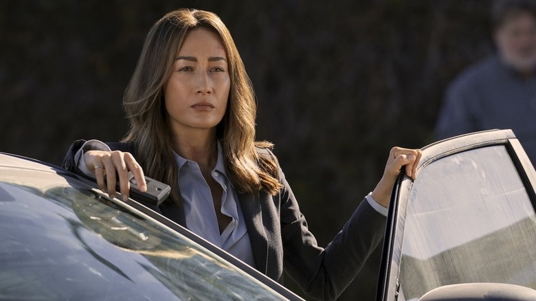 Maggie Q as Renee Ballard standing next to open car door in Ballard