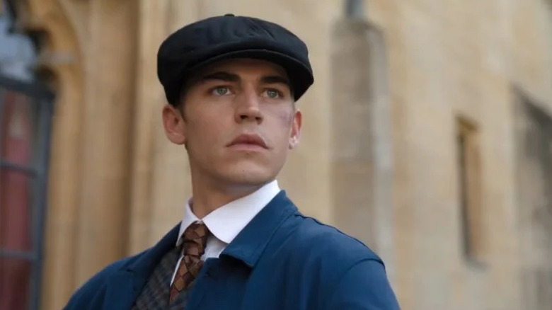 Hero Fiennes Tiffin as young Sherlock Holmes in blue suit and cap in Young Sherlock