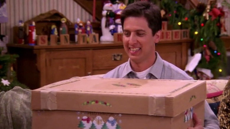 Ray Romano as Ray Barone smiles at a present in Everybody Loves Raymond