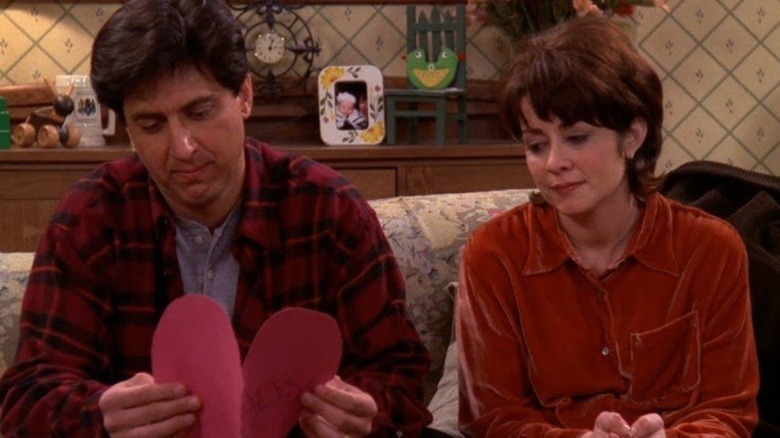 Ray Romano as Ray Barone and Patricia Heaton as Debra Barone look at a paper heart in Everybody Loves Raymond