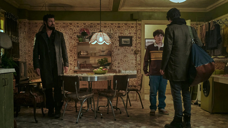 Billy Butcher (Karl Urban) watches his younger self (Luca Villacis) speak with Lenny Butcher (Jack Fulton) in The Boys