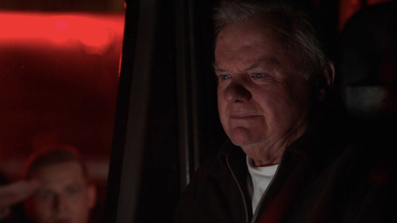 Red sitting in fire truck as Buck salutes him outside