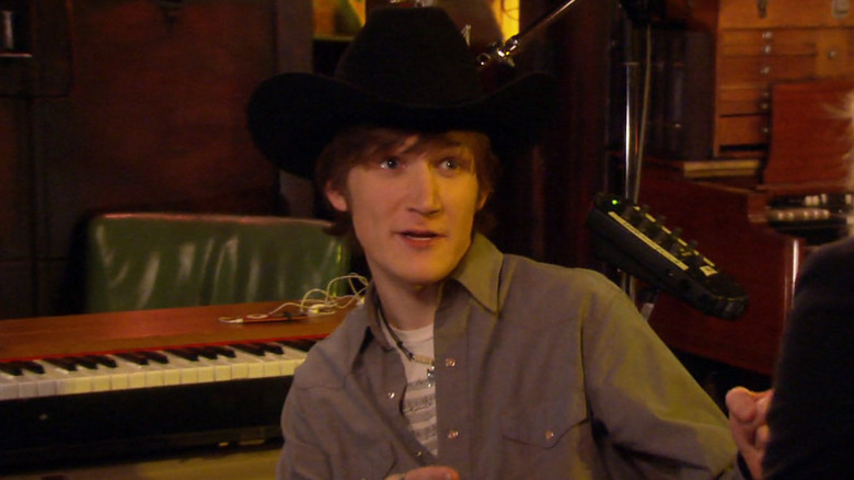 Bo Burnham as Chipp McCapp in a cowboy hat sitting by a piano in Parks & Recreation