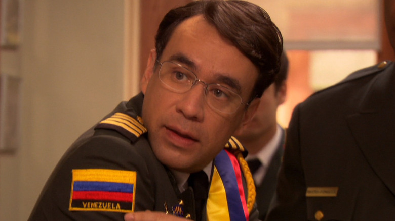 Fred Armisen as Raul pointing to a patch of the Venezuelan flag on his jacket in Parks & Recreation