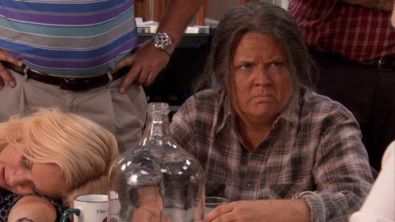 Paula Pell as Tammy Zero frowning next to Amy Poehler as Leslie Knope sleeping in Parks & Recreation