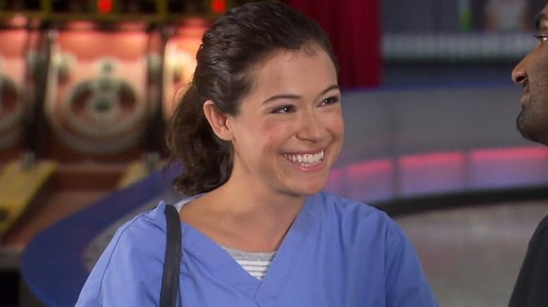 Tatiana Maslany as Nadia Stasky in nurse scrubs smiling at Aziz Ansari as Tom in Parks & Recreation