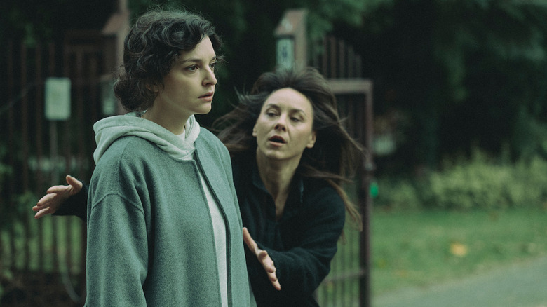 A zoned out Greta Rembiewska (Maria Dębska) stands by a playground as Sandra Kowalska (Monika Krzywkowska) reaches for her in Just One Look