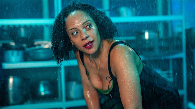 Kat Donovan (Rosalind Eleazar) crouches in a kitchen as water falls on her in Missing You