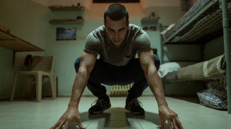 Mateo Vidal (Mario Casas) crouches and touches the floor of a cell in The Innocent