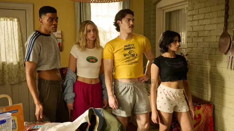 The characters of Adults stand together in a kitchen.