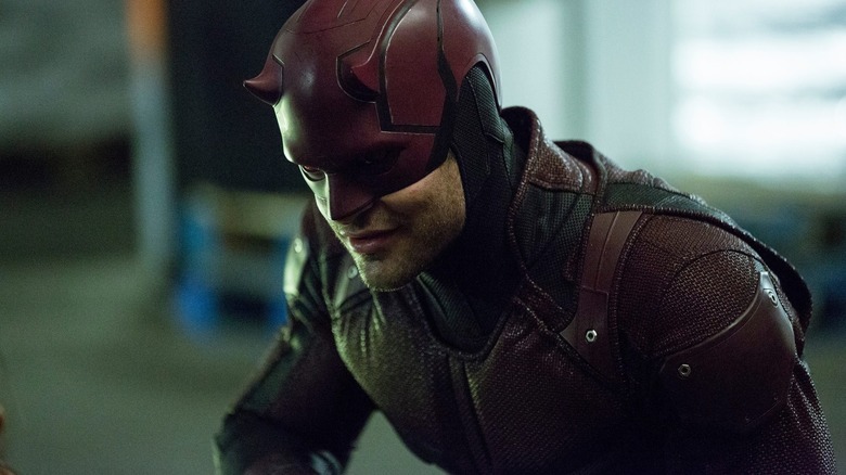 Matt Murdock (Charlie Cox) grins while kneeling in Daredevil