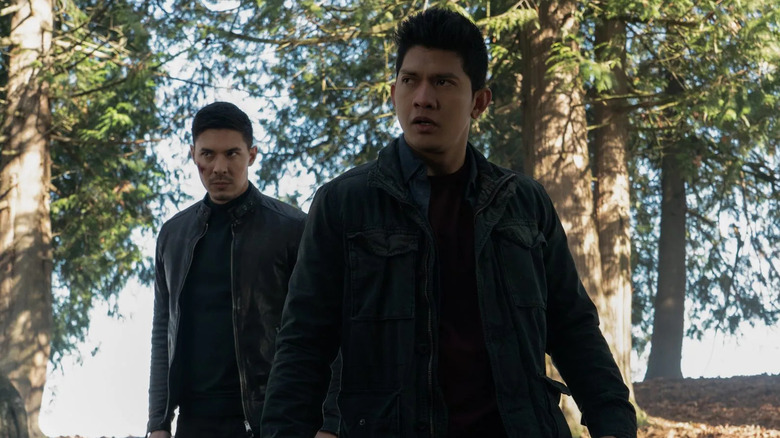 Lu Xin Lee (Lewis Tan) and Kai Jin (Iko Uwais) stand ready in a forest in Wu Assassins