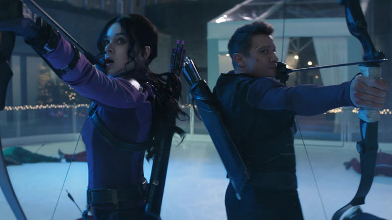 Hailee Steinfeld and Jeremy Renner as Kate Bishop and Clint Barton drawing their bows back-to-back on an ice rink in Hawkeye