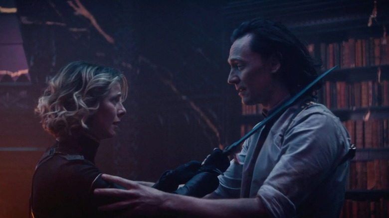 Sophia Di Martino as Sylvie holding a sword to Tom Hiddleston as Loki's neck in Loki season 1