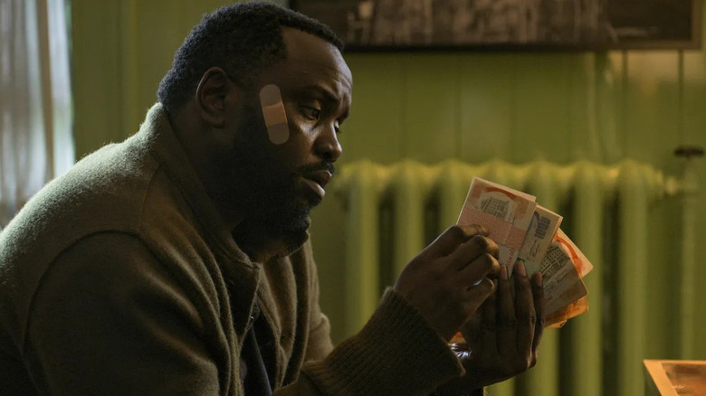 Brian Tyree Henry as Ray Driscoll, counting money in Dope Thief.