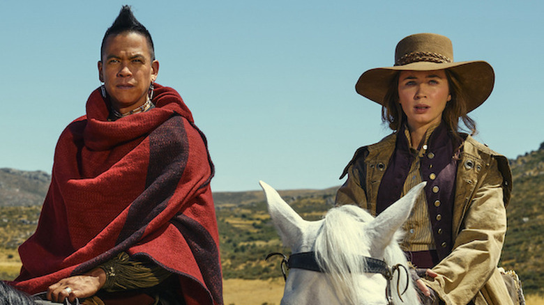 Chaske Spencer as Eli sitting on  horse next to Emily Blunt as Cornelia also on horse in The English