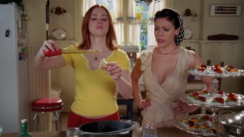 Phoebe watching Paige mix ingredients in a cauldron