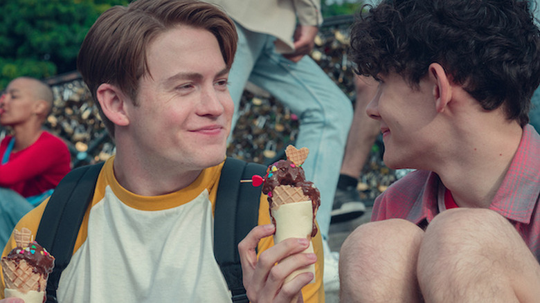 Kit Connor as Nick holding an ice cream and smiling at Joe Locke as Charlie, also holding ice cream cone in Heartstopper