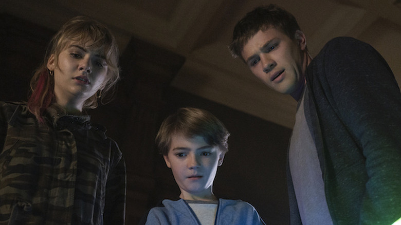 Emilia Jones as Kinsey, Jackson Robert Scott as Bode, and Connor Jessup as Tyler, all looking down at something in Locke & Key