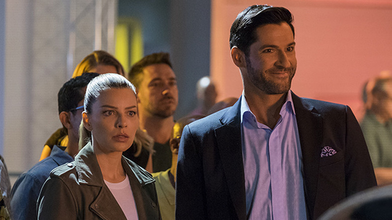 Lauren German as Chloe looking shocked next to smirking Tom Ellis as Lucifer in Lucifer