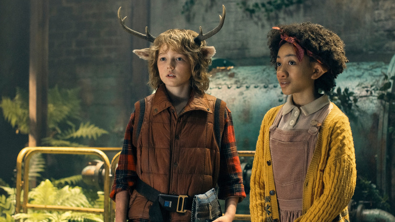Christian Convery as Gus, with deer antlers and ears standing in forest in Sweet Tooth