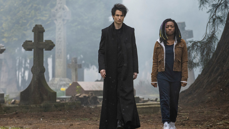 Tom Sturridge as Dream walking through graveyard next to Kirby Howell-Baptiste as Death in The Sandman