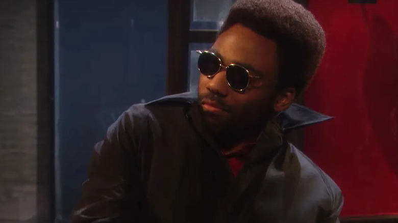 Donald Glover as Razz P. Berry wearing sunglasses and leaning back on SNL