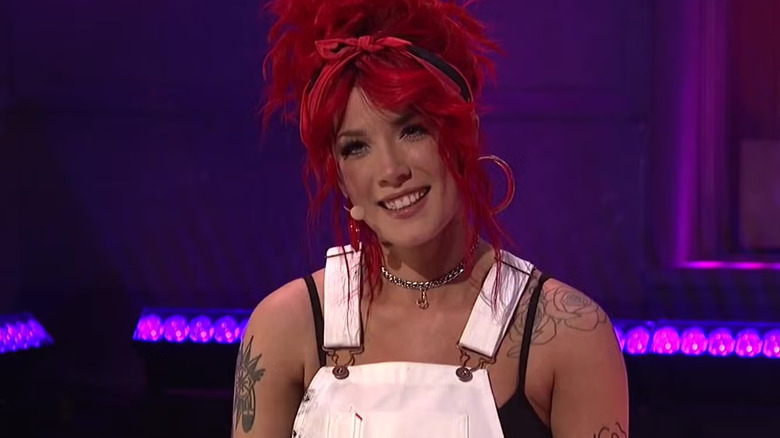 Halsey with red hair smiling after a performance on SNL