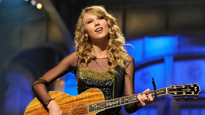 Taylor Swift playing acoustic guitar in her monologue on SNL