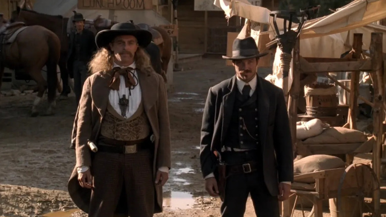 Wild Bill Hickok (Keith Carradine) and Seth Bullock (Timothy Olyphant) stand in a muddy street in Deadwood