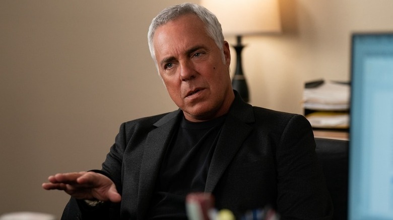 Titus Welliver as Harry Bosch sitting in black suit in Bosch: Legacy