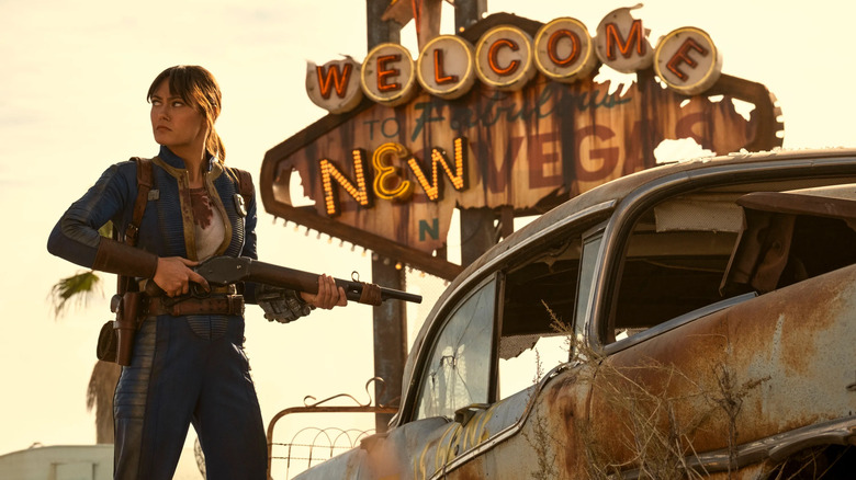Ella Purnell as Lucy MacLean, standing with a gun in New Vegas.
