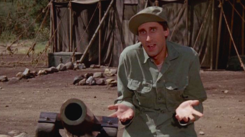 Igor Straminsky (Jeff Maxwell) sheepishly stands next to a mortar in M*A*S*H