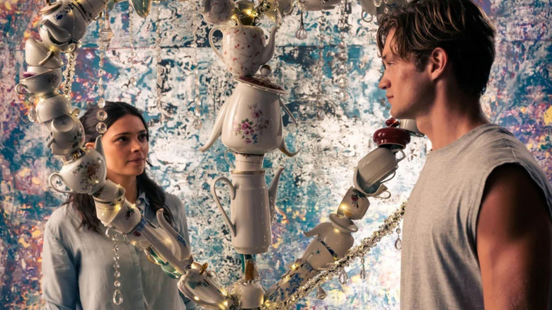 Harriet Herbig-Matten as Ruby and Damian Hardung as James looking at each other from across a teapot art installation in Maxton Hall