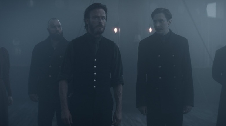 Eyk Larsen (Andreas Pietschmann) stands on a foggy ship deck with his crew in 1899