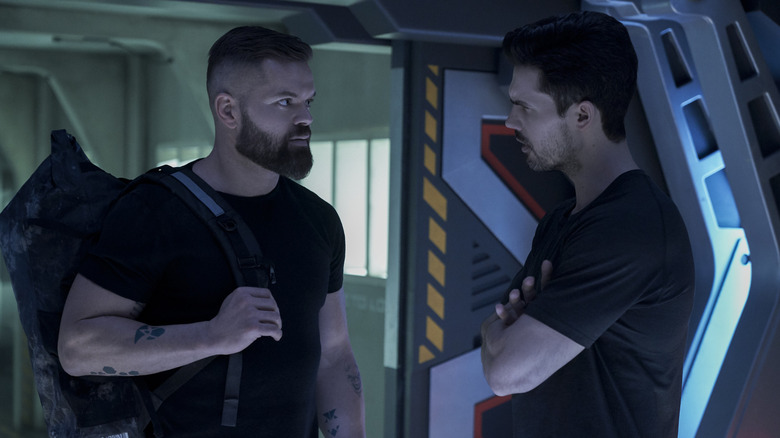 Wes Chatham's Amos Burton and Steven Strait's James Holden looking at each other on The Expanse